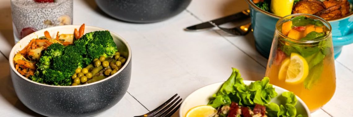 A vibrant assortment of healthy bowls and drinks showcasing fresh ingredients like broccoli and citrus.